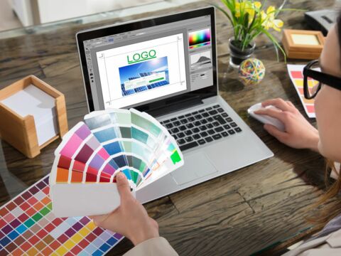 Stock-Foto ID: 673636411 - Bild: Eine Frau, die Farbtöne mit einem Laptop mit Logo-Design-Software auf dem Bildschirm hält Andrey_Popov